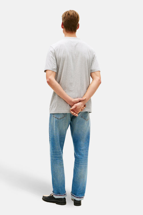 T-shirt à manches courtes gris de TOMMY HILFIGER, porté avec un jean bleu et des mocassins noirs, vue de dos.