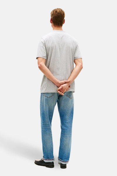 T-shirt à manches courtes gris de TOMMY HILFIGER, porté avec un jean bleu et des mocassins noirs, vue de dos.