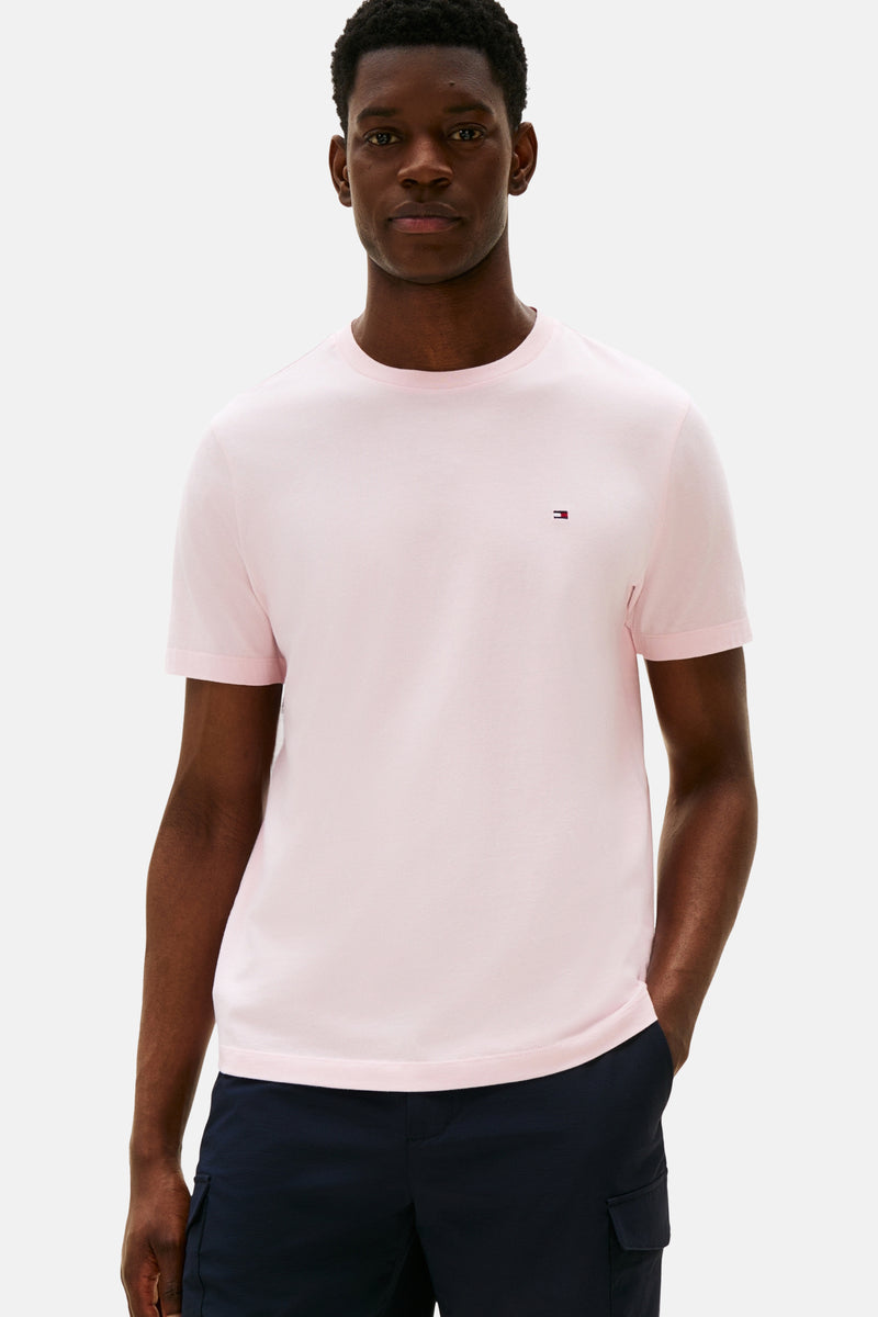 T-shirt rose à manches courtes de TOMMY HILFIGER, porté avec un pantalon bleu marine.