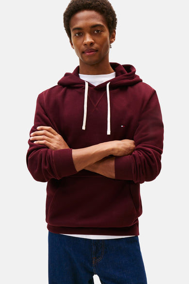 Bordeaux hoodie van Tommy Hilfiger, gedragen met een wit T-shirt en een blauwe jeans.