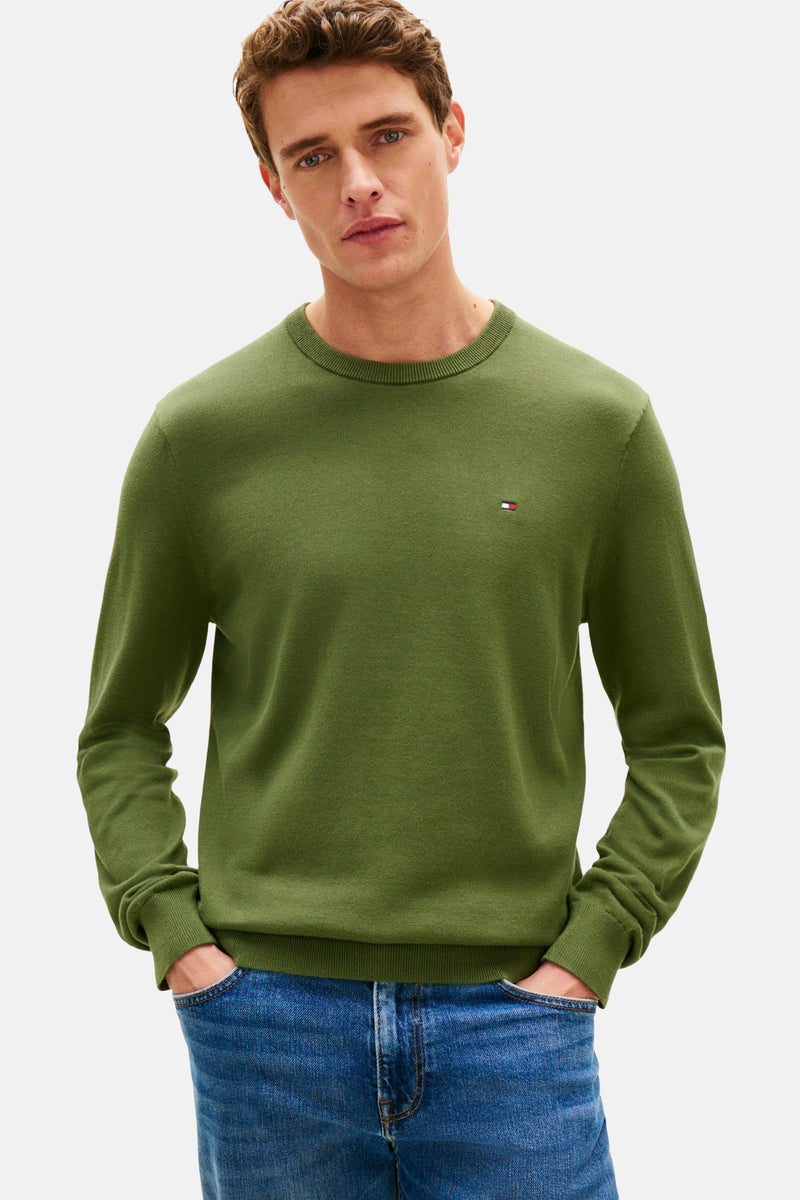 Groene trui met ronde hals van TOMMY HILFIGER, gedragen met een blauwe spijkerbroek en bruine loafers, achtergezicht.