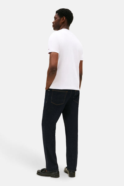 T-shirt blanc à manches courtes de Tommy Hilfiger, porté avec un jean indigo et des mocassins.