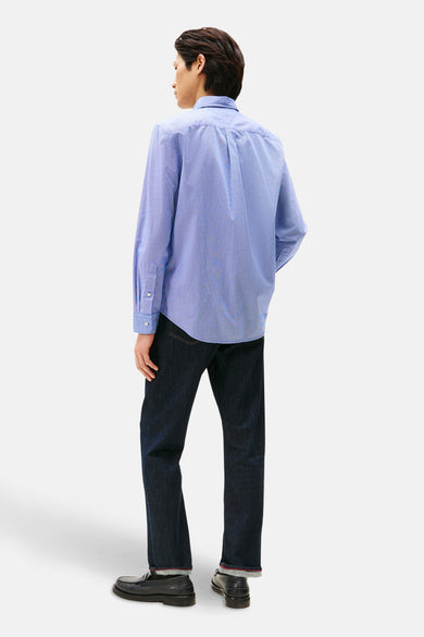 Blauw overhemd met lange mouwen en patroon van TOMMY HILFIGER, gedragen met een donkere spijkerbroek en zwarte loafers.