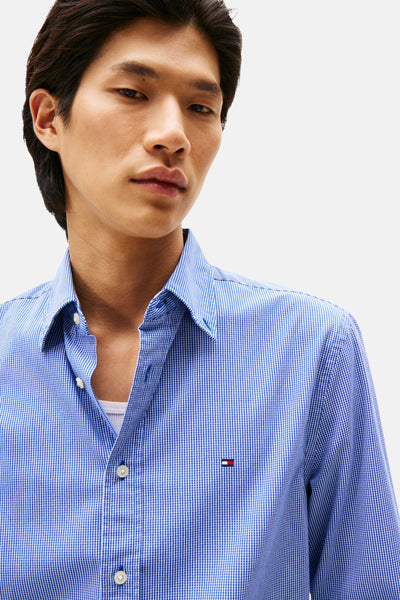 Chemise à manches longues bleue à carreaux by TOMMY HILFIGER, avec un t-shirt blanc visible.