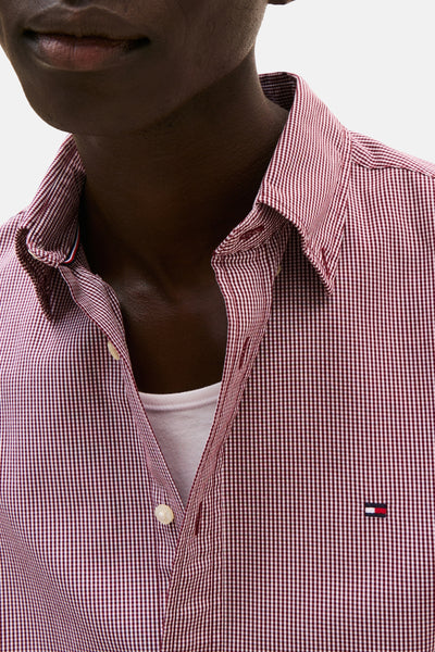 Chemise à manches longues rouge à carreaux de TOMMY HILFIGER, portée ouverte sur un t-shirt blanc.