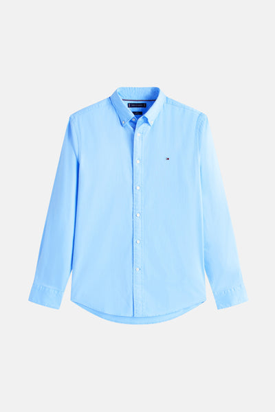 Chemise à manches longues bleue de TOMMY HILFIGER, boutonnée avec logo discret sur la poitrine.