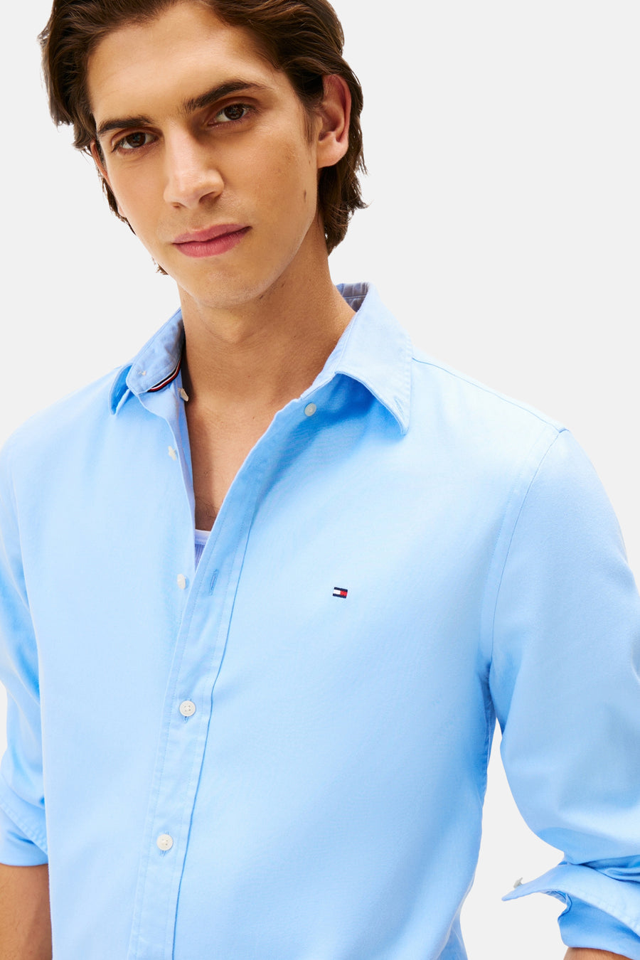 Chemise bleue à manches longues de TOMMY HILFIGER, avec le logo discret et boutons blancs.