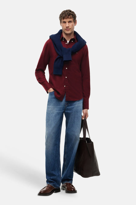 Chemise bordeaux à manches longues par TOMMY HILFIGER, portée avec écharpe bleue, jeans et sac en cuir, vue de face.
