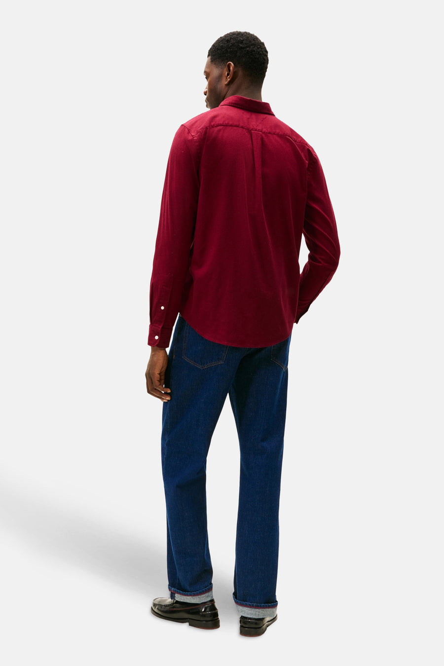 Chemise bordeaux à manches longues de TOMMY HILFIGER, avec fermeture boutonnée, portée avec un jean bleu foncé.