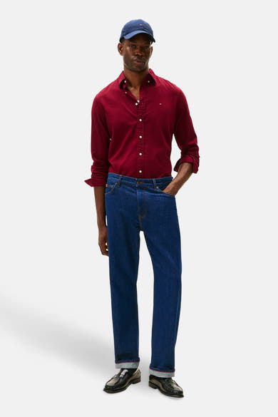 Chemise à manches longues bordeaux de TOMMY HILFIGER, portée avec un jean bleu et des mocassins noirs.
