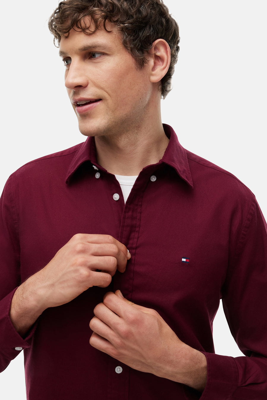 Chemise bordeaux à manches longues par TOMMY HILFIGER, boutonnée avec logo brodé sur poitrine, vue de face sur modèle