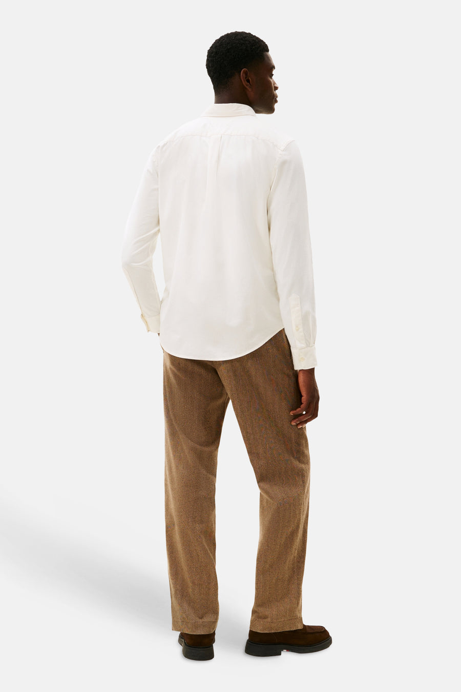 Chemise à manches longues écru de TOMMY HILFIGER, avec un pantalon marron à motif et des chaussures noires.
