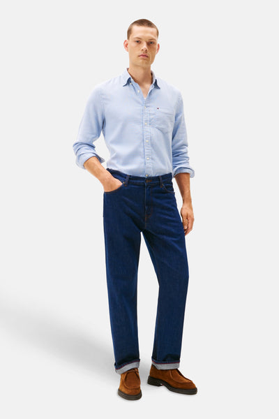Blauw overhemd met lange mouwen van TOMMY HILFIGER, gedragen met een donkere spijkerbroek en bruine loafers.