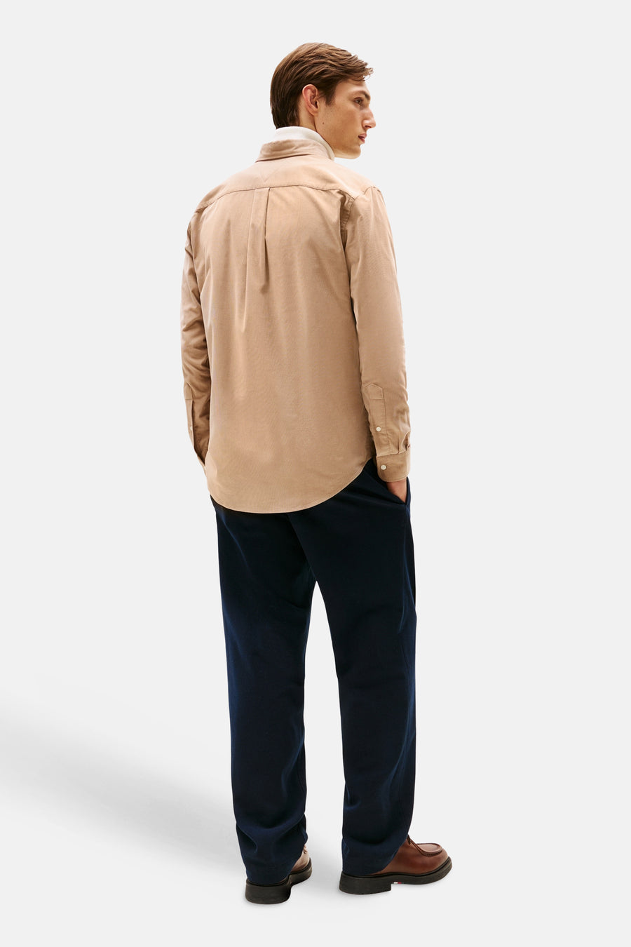 Beige hemd van TOMMY HILFIGER, lange mouwen, gedragen met een witte coltrui en een wijde marineblauwe broek.