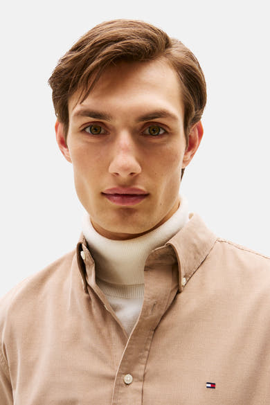 Beige ribfluwelen hemd van Tommy Hilfiger, gedragen met een witte coltrui.