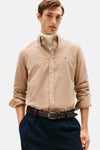 Beige hemd van TOMMY HILFIGER, gedragen met een witte coltrui en een marineblauwe broek met een bruine riem.