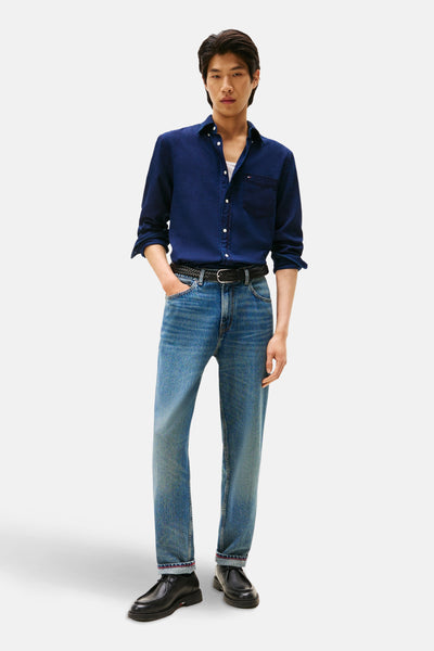 Blauw overhemd met lange mouwen van Tommy Hilfiger, open gedragen met een wit T-shirt en een blauwe jeans.