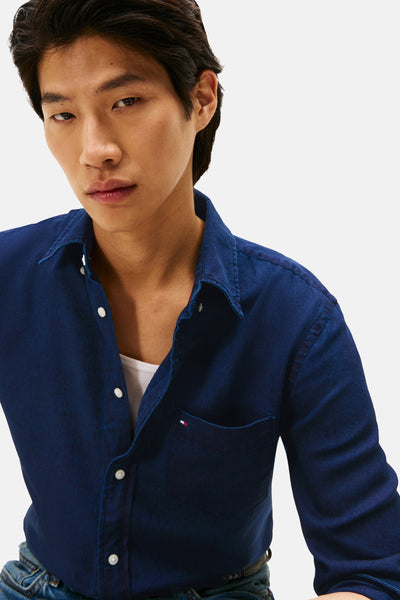 Chemise à manches longues bleue de TOMMY HILFIGER, avec poche poitrine et boutons blancs.