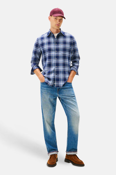 Blauw geruit overhemd met lange mouwen van TOMMY HILFIGER, gedragen met een spijkerbroek en een bordeauxrode pet.