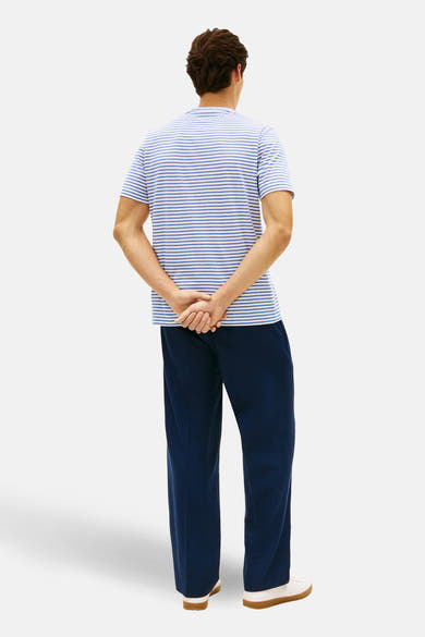 T-shirt à manches courtes bleu de TOMMY HILFIGER avec un motif rayé et porté avec un pantalon bleu.
