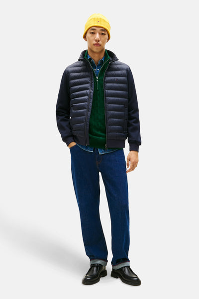 Blauwe TOMMY HILFIGER jas gedragen met een groene trui, een spijkeroverhemd en een gele muts.