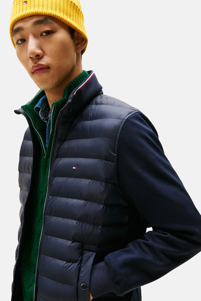 Veste bleu marine de TOMMY HILFIGER, portée avec un pull vert et un bonnet jaune.