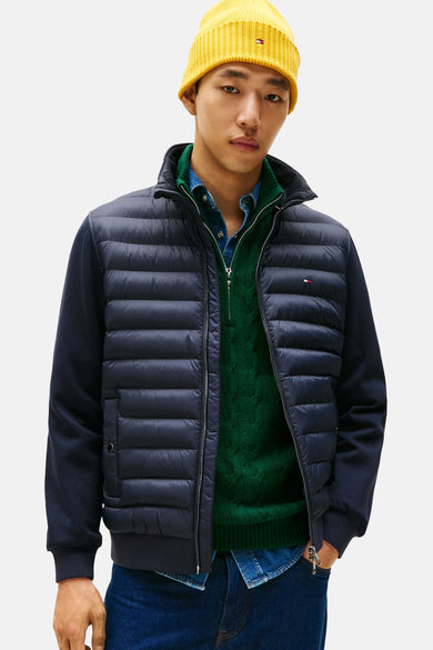 Blauwe jas van TOMMY HILFIGER, gedragen met een groene trui, een spijkeroverhemd en een gele muts.