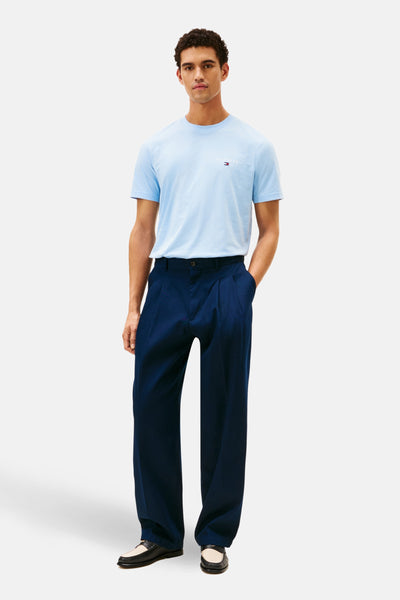 T-shirt bleu à manches courtes de TOMMY HILFIGER, porté avec un pantalon bleu marine et des mocassins bicolores.