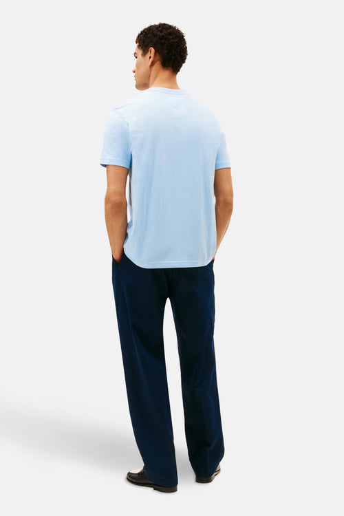 T-shirt à manches courtes bleu de Tommy Hilfiger, porté avec un pantalon bleu marine et des chaussures bicolores, vue arrière.