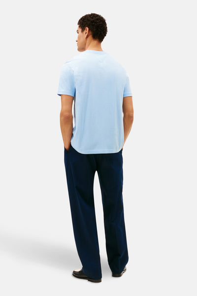 T-shirt à manches courtes bleu de Tommy Hilfiger, porté avec un pantalon bleu marine et des chaussures bicolores, vue arrière.