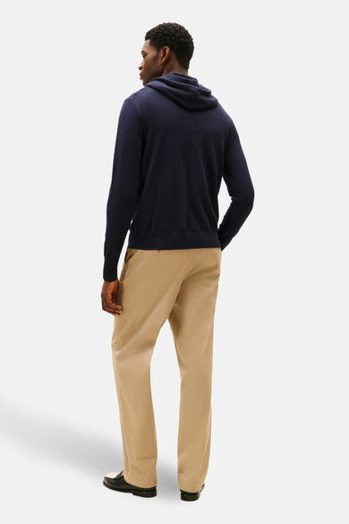 Sweat à capuche bleu de TOMMY HILFIGER, porté avec un pantalon beige et des mocassins noirs et blancs.