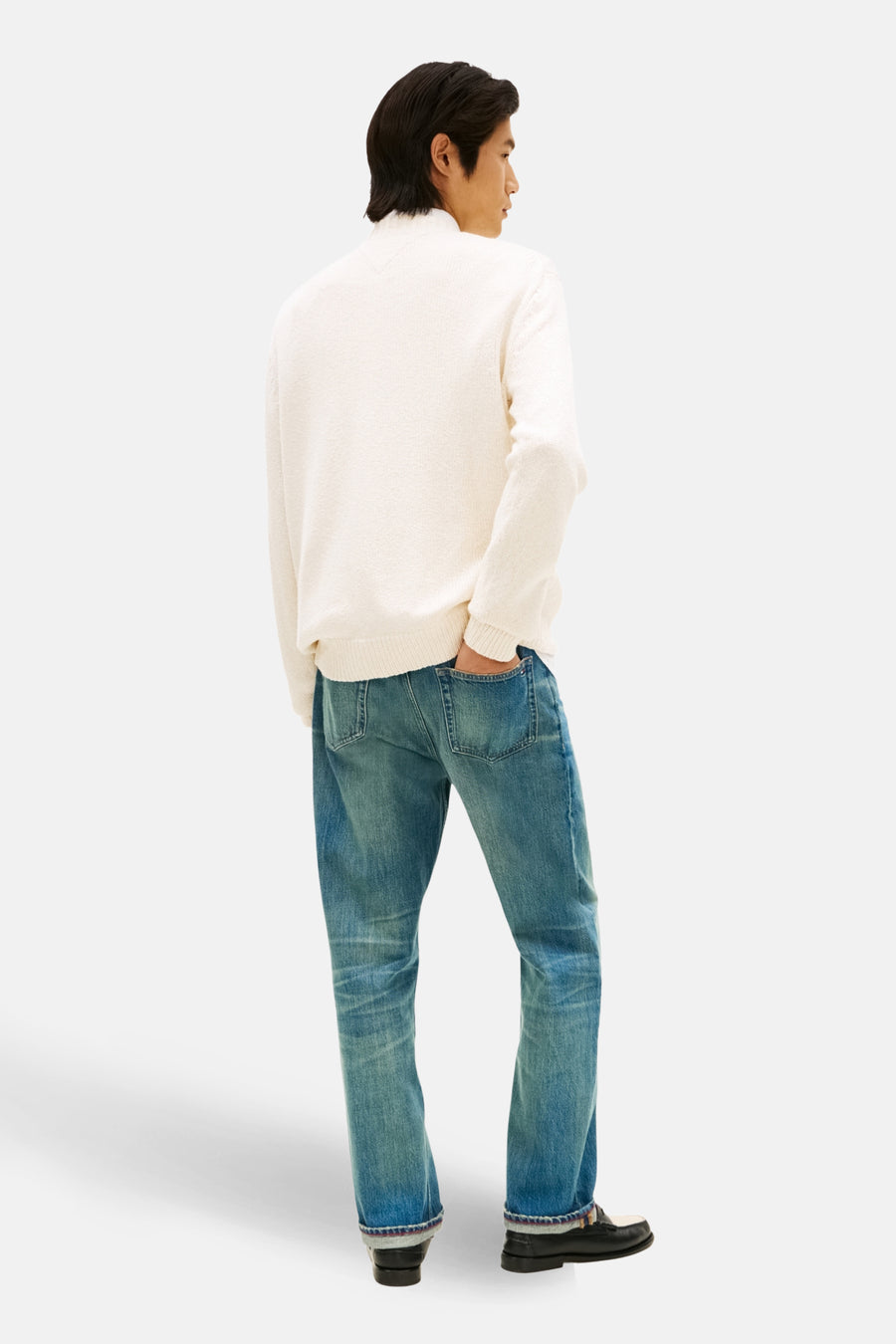 Pull à col rond en coton écru de TOMMY HILFIGER, porté avec un jean bleu et des mocassins noirs, vue de dos.