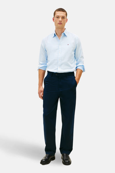 Blauw overhemd met lange mouwen van TOMMY HILFIGER, gedragen met een marineblauwe broek en zwarte leren schoenen.