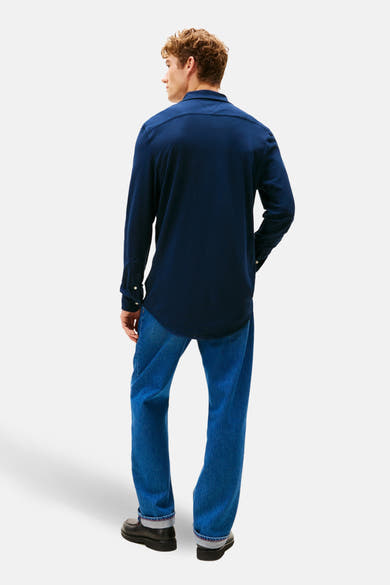 Chemise à manches longues bleue by TOMMY HILFIGER, portée avec un jean et des chaussures noires, vue de dos.