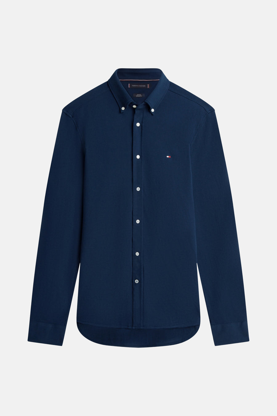 Chemise bleu marine à manches longues de TOMMY HILFIGER avec une boutonnière blanche et le logo sur la poitrine.
