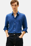 Chemise bleue à manches longues de TOMMY HILFIGER, portée avec un t-shirt blanc et un jean foncé