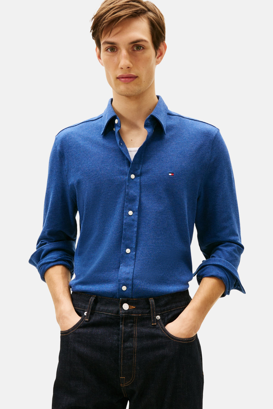 Chemise bleue à manches longues de TOMMY HILFIGER, portée avec un t-shirt blanc et un jean foncé