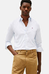 Chemise à manches longues bleue de TOMMY HILFIGER, à motif discret, portée avec un pantalon chino marron.