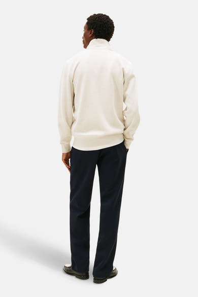 Sweat écru de TOMMY HILFIGER, porté avec un pantalon bleu marine et des mocassins noirs, vue de dos.