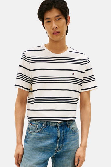 T-shirt à manches courtes écru par Tommy Hilfiger, à rayures marine, porté avec un jean bleu.