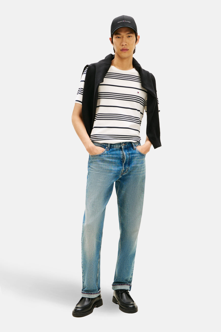 T-shirt à manches courtes écru de Tommy Hilfiger avec rayures horizontales et pull noir noué sur les épaules.