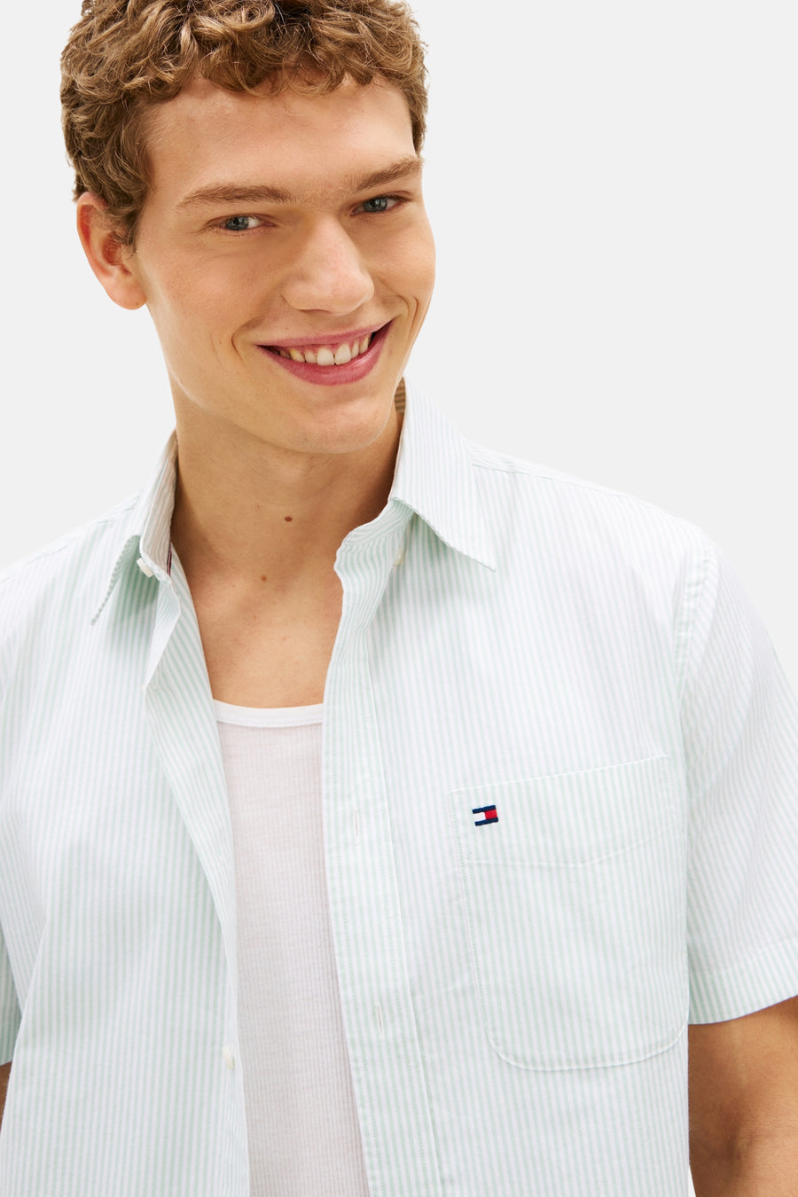Wit gestreept overhemd met korte mouwen van TOMMY HILFIGER, gedragen open over een wit hemdje.