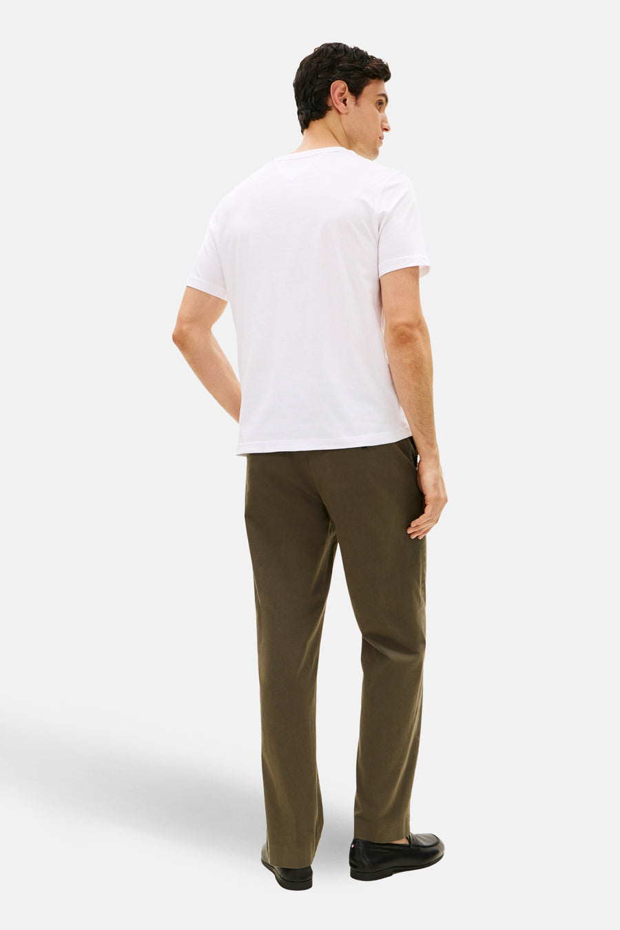 T-shirt à manches courtes blanc de TOMMY HILFIGER, porté avec un pantalon vert olive et des mocassins noirs, vue de dos.
