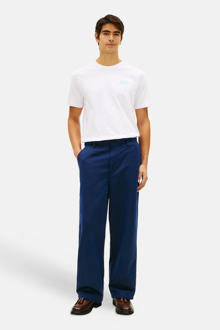 T-shirt blanc à manches courtes de TOMMY HILFIGER avec un logo turquoise clair sur la poitrine.