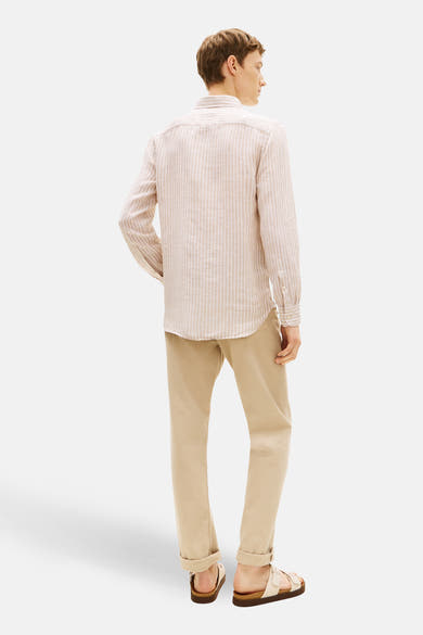 Chemise à manches longues beige rayée de TOMMY HILFIGER, avec pantalon beige et sandales.