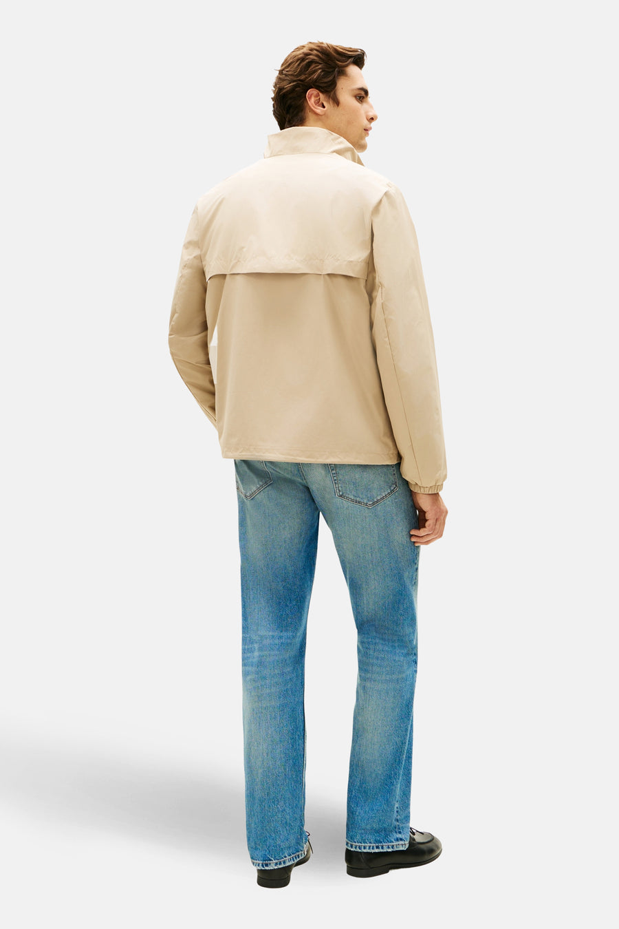 Veste beige de TOMMY HILFIGER, portée avec un jean bleu et des chaussures noires, vue de dos.
