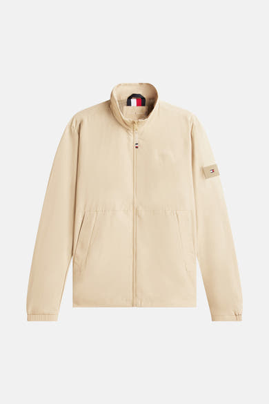 Veste beige de TOMMY HILFIGER avec fermeture éclair et logo discret sur la poitrine.
