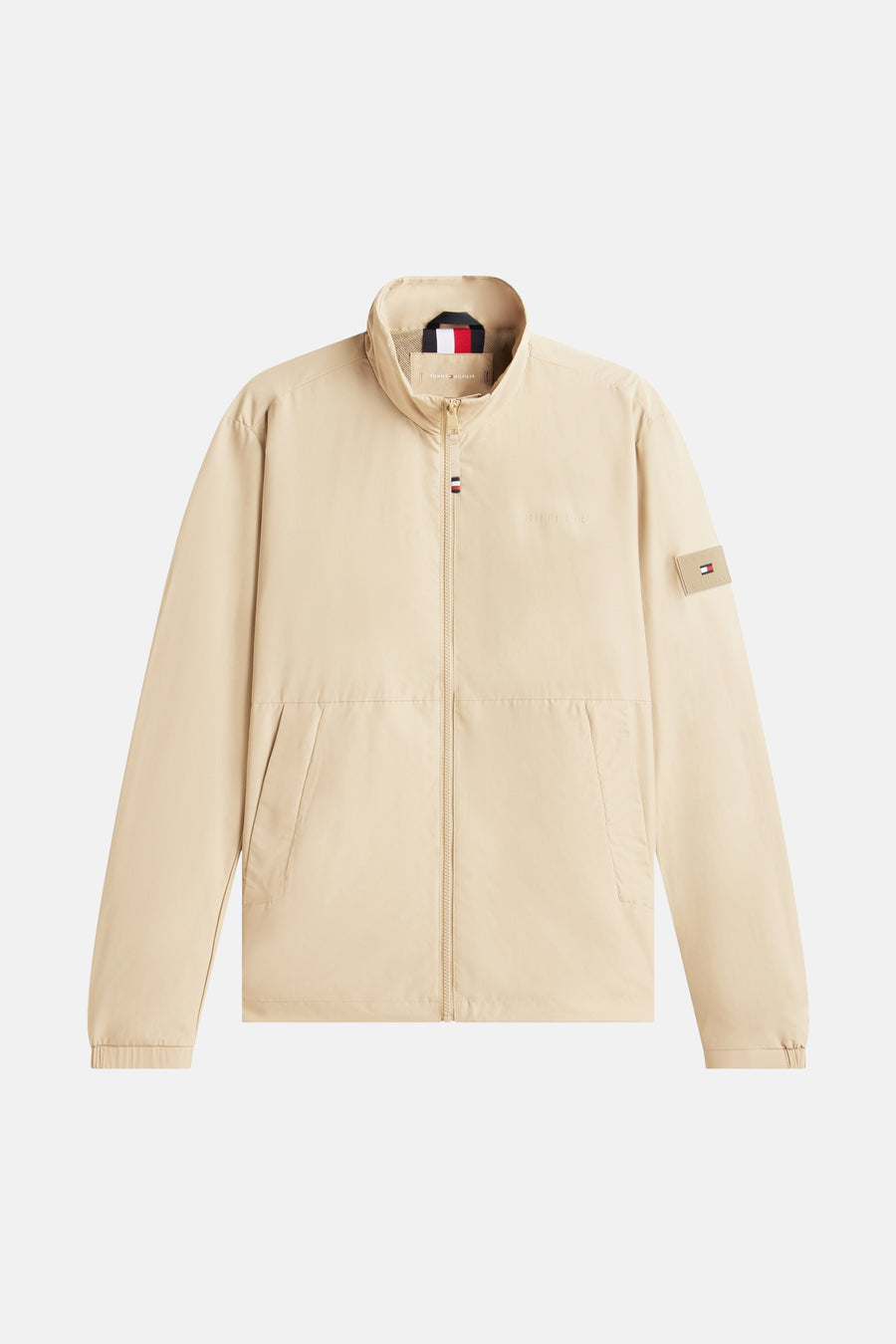 Veste beige de TOMMY HILFIGER avec fermeture éclair et logo discret sur la poitrine.