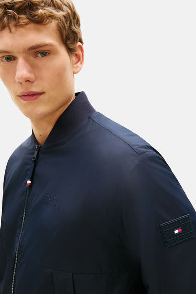 Veste bleu marine de Tommy Hilfiger, avec fermeture éclair et logo discret sur la poitrine.