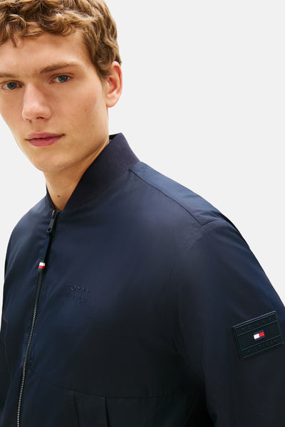 Veste bleu marine de Tommy Hilfiger, avec fermeture éclair et logo discret sur la poitrine.